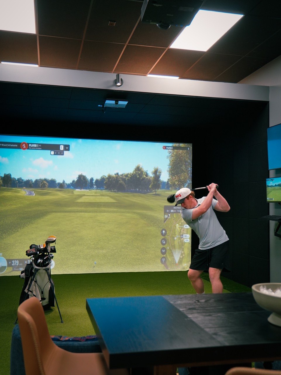 Golfer mid-swing at The Players Lounge simulator